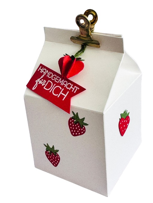 Geschenkverpackung mit einer Leckereibox und Erdbeeren
