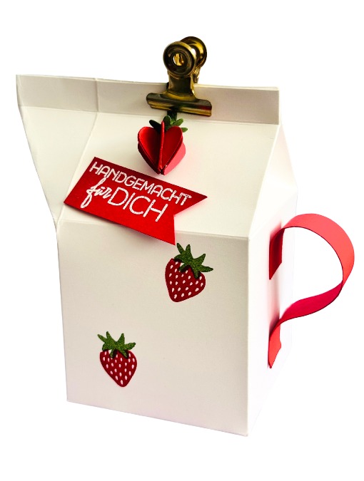 Geschenkverpackung mit einer Leckereibox und Erdbeeren